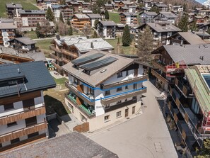 Ein mehrstöckiges Gebäude mit modernem Design, mit Balkonen und einem flachen Dach mit Solaranlagen.