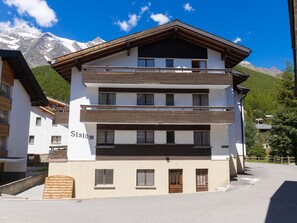 A multi-story hotel with a modern design, featuring balconies and a view of snow-capped mountains. - Haus Slalom by Interhome (Saas-Fee)