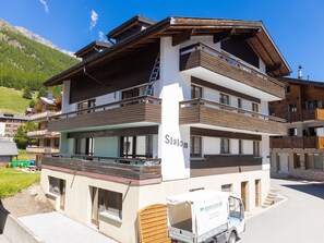 A multi-story hotel with balconies, a visible name 'Slalom,' and a parked delivery truck. - Haus Slalom by Interhome (Saas-Fee)
