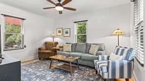 A living room with a sofa, armchairs, a coffee table, and a ceiling fan. - Cross Road Cottage - NEW! Home in Hancock (Hancock)