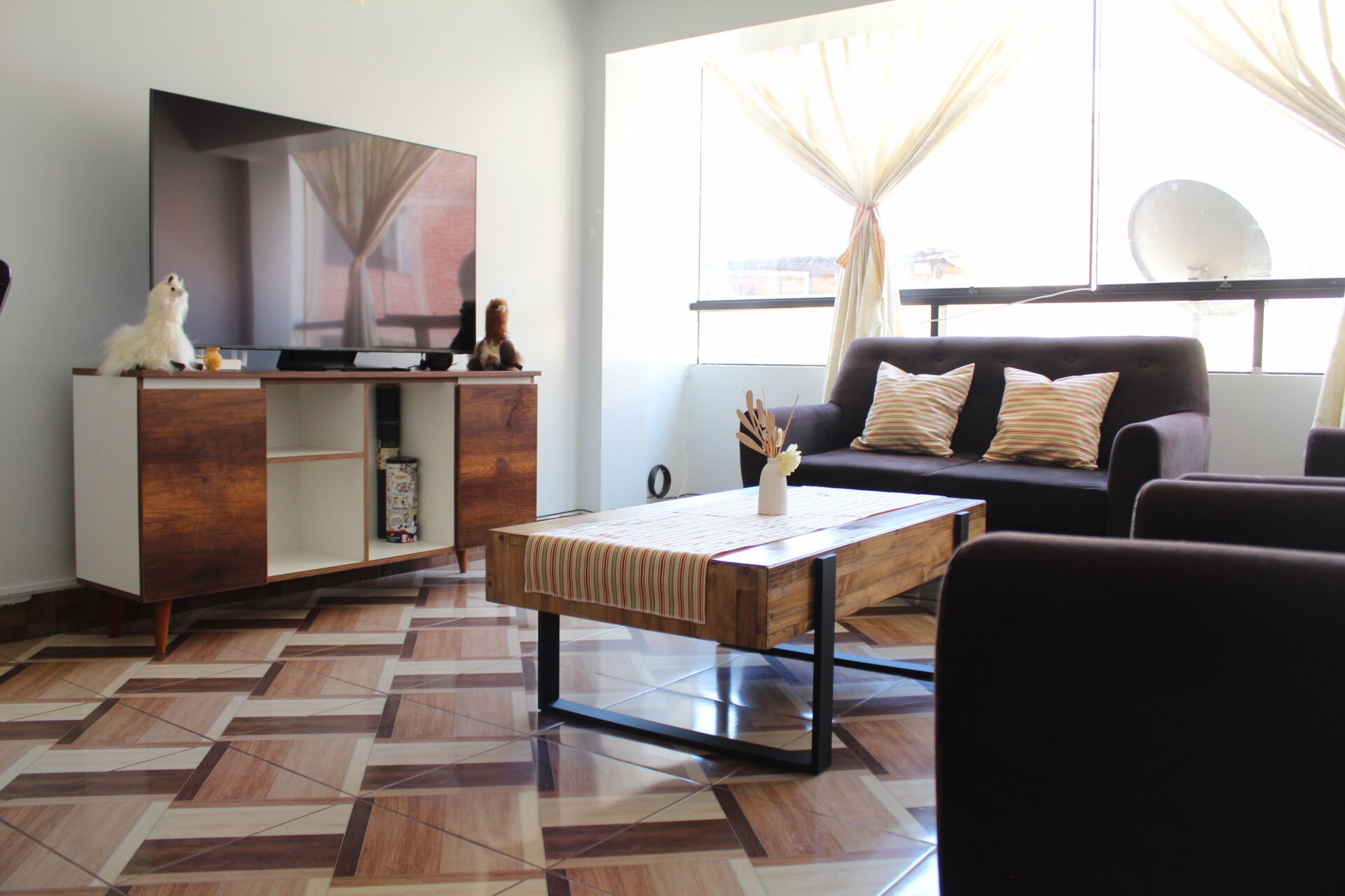 A living room with a sofa, a coffee table, a TV, and a cabinet.