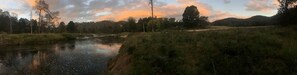 Un fiume con un sentiero lungo la riva, circondato da alberi e vegetazione.