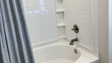 Une salle de bain équipée d’une baignoire, d’une douche et d’un porte-serviettes.