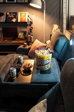 A cozy seating area with a popcorn container, snacks, and drinks. - Spacious Vibey Retreat with a Movie Projector, Electric Recliner and & Balcony (Melbourne)