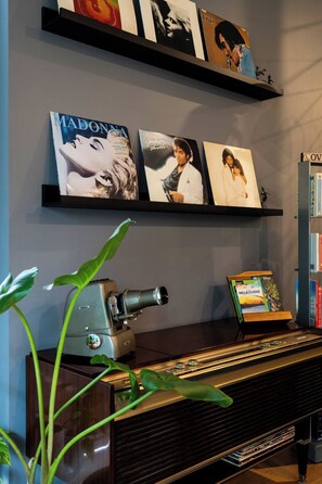 A room with a vintage camera, a piano, and framed album covers on the wall. - Spacious Vibey Retreat with a Movie Projector, Electric Recliner and & Balcony (Melbourne)