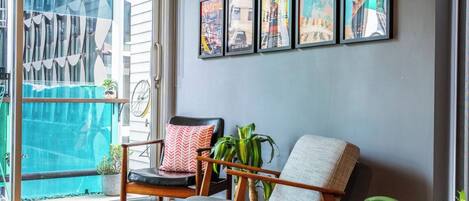 A modern living room with a grey sofa, a wooden coffee table, and a green telephone.