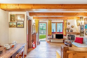 A wooden-floored living room with a fireplace, a television, and a sofa. - Courmayeur Apartment X6 Parking, Courmayeur, Italy (Courmayeur)