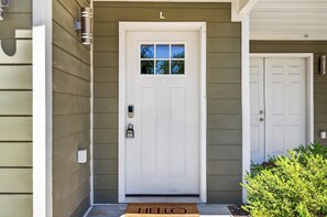 A white front door with a small window, a mailbox, and a doorbell.