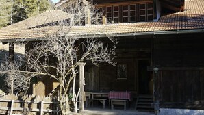 A rustic wooden cabin with a tiled roof, a porch with benches, and a wooden fence. - Auf der Mauer Appartement/Fewo, Dusche oder Bad, WC, 2 Schlafräume by Interhome (Oberwil)