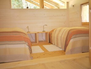 A cabin with two beds, a small table, and a window. - Auf der Mauer Appartement/Fewo, Dusche oder Bad, WC, 2 Schlafräume by Interhome (Oberwil)