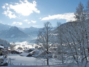 Eine verschneite Berglandschaft mit Gebäuden und Bäumen.