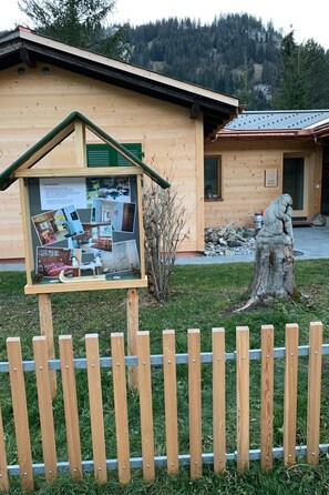 A wooden cabin with a glass display case containing photos and information. - Andrea Appartement/Fewo, Dusche oder Bad, WC, 3 Schlafräume 4-Zimmerhaus by Interhome (Lenk)