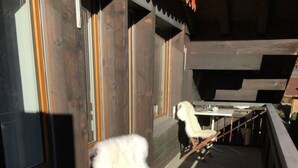 A room with a wooden floor, a white chair, and a table with a chair. - Turmalin 2. Stock Appartement/Fewo, Dusche, WC, 2 Schlafräume 5-Bettwohnung by Interhome (Lenk)