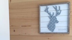 A wooden wall with a framed deer head artwork and the word 'HOME' below it. - Turmalin 2. Stock Appartement/Fewo, Dusche, WC, 2 Schlafräume 5-Bettwohnung by Interhome (Lenk)