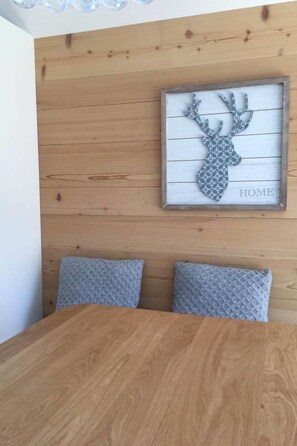 Eine Holzwand mit einem gerahmten Hirschgemälde und dem Wort 'HOME' darunter.