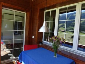 Een kamer met een tafel bedekt met blauw, een lamp en een vaas met bloemen.