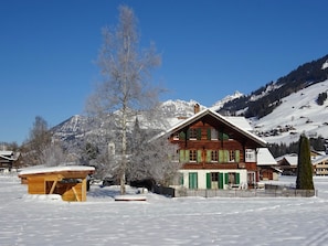 A wooden chalet with a snow-covered roof, surrounded by a snowy landscape and mountains. - Lischenhaus - Strubel Appartement/Fewo, Dusche oder Bad, WC, 2 Schlafräume by Interhome (Lenk)