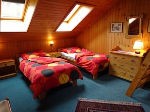 A room with two beds, a dresser, a mirror, and a skylight. - Lischenhaus - Strubel Appartement/Fewo, Dusche oder Bad, WC, 2 Schlafräume by Interhome (Lenk)
