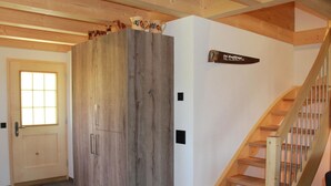A wooden staircase with a handrail and a door with a window. - Alphaus Hasler Appartement/Fewo, Dusche, WC, 4 oder mehr Schlafräume by Interhome (Lenk)