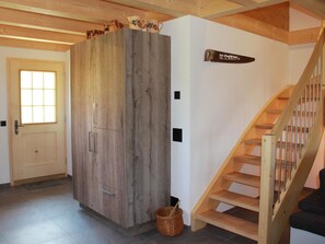 Eine Holztreppe mit Handlauf und einer Tür mit Fenster.