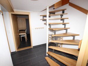 A staircase with wooden steps and metal railings, leading to a room with a chair and a table. - Möösli Appartement/Fewo, Dusche oder Bad, WC, 4 oder mehr Schlafräume by Interhome (Lenk)