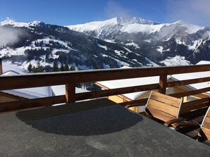 A wooden deck with a view of snow-covered mountains. - Chalet Weitblick Appartement/Fewo, Dusche oder Bad, WC, Balkon by Interhome (Lenk)
