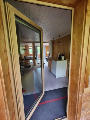 A wooden interior with a kitchen area, a dining space, and a living area. - Wildbach Appartement/Fewo, Dusche oder Bad, WC, 2 Schlafräume 4-Bett-Wohnung by Interhome (Lenk)