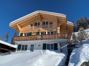 A multi-story wooden chalet with a balcony, surrounded by snow-covered trees. - Meieli Appartement/Fewo, Dusche oder Bad, WC, 1 Schlafraum 2-Bett-Wohnung by Interhome (Lenk)