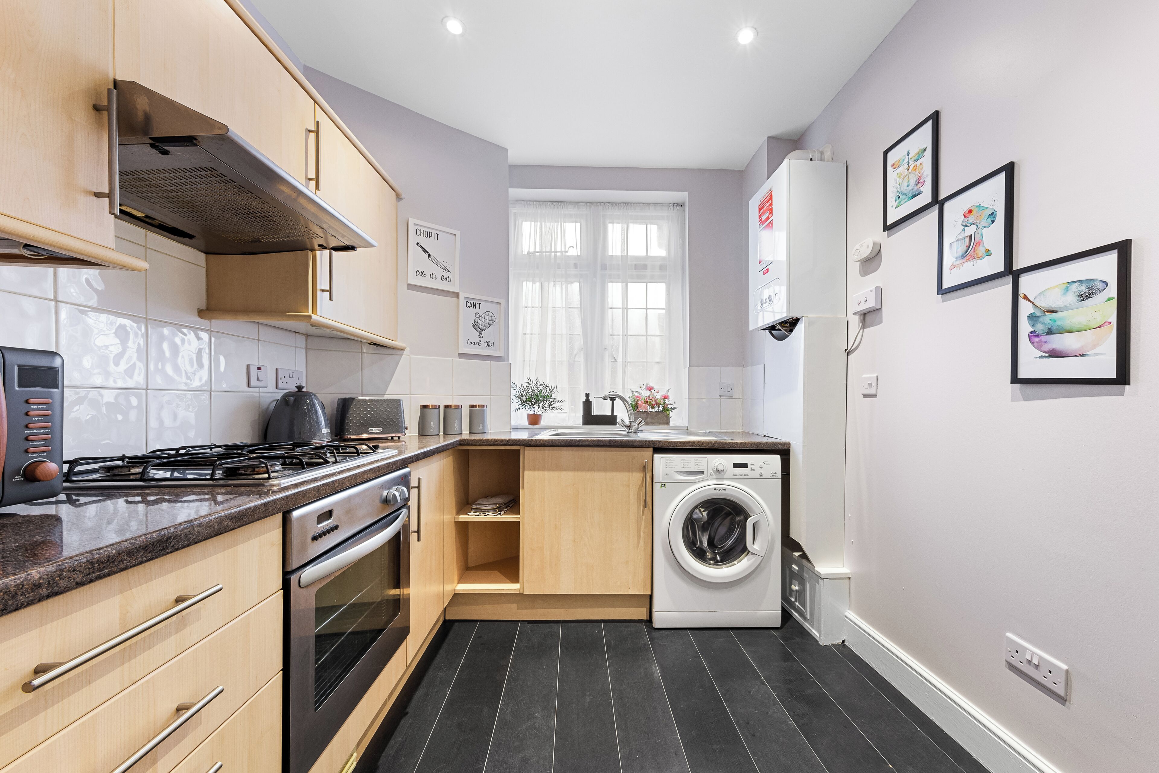 A modern kitchen with a gas stove, oven, and built-in dishwasher.