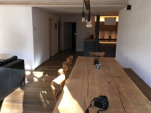 A spacious dining area with a wooden table, chairs, and a camera on the table. - am Lee Appartement/Fewo, Dusche und Bad, WC, 2 Schlafräume 6-Bettwohnung by Interhome (Lenk)