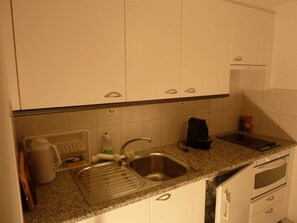 A kitchen with a stainless steel sink, a coffee maker, and a kettle. - Bach Appartement/Fewo, Dusche oder Bad, WC, 1 Schlafraum 2-Bett-Wohnung by Interhome (Lenk)