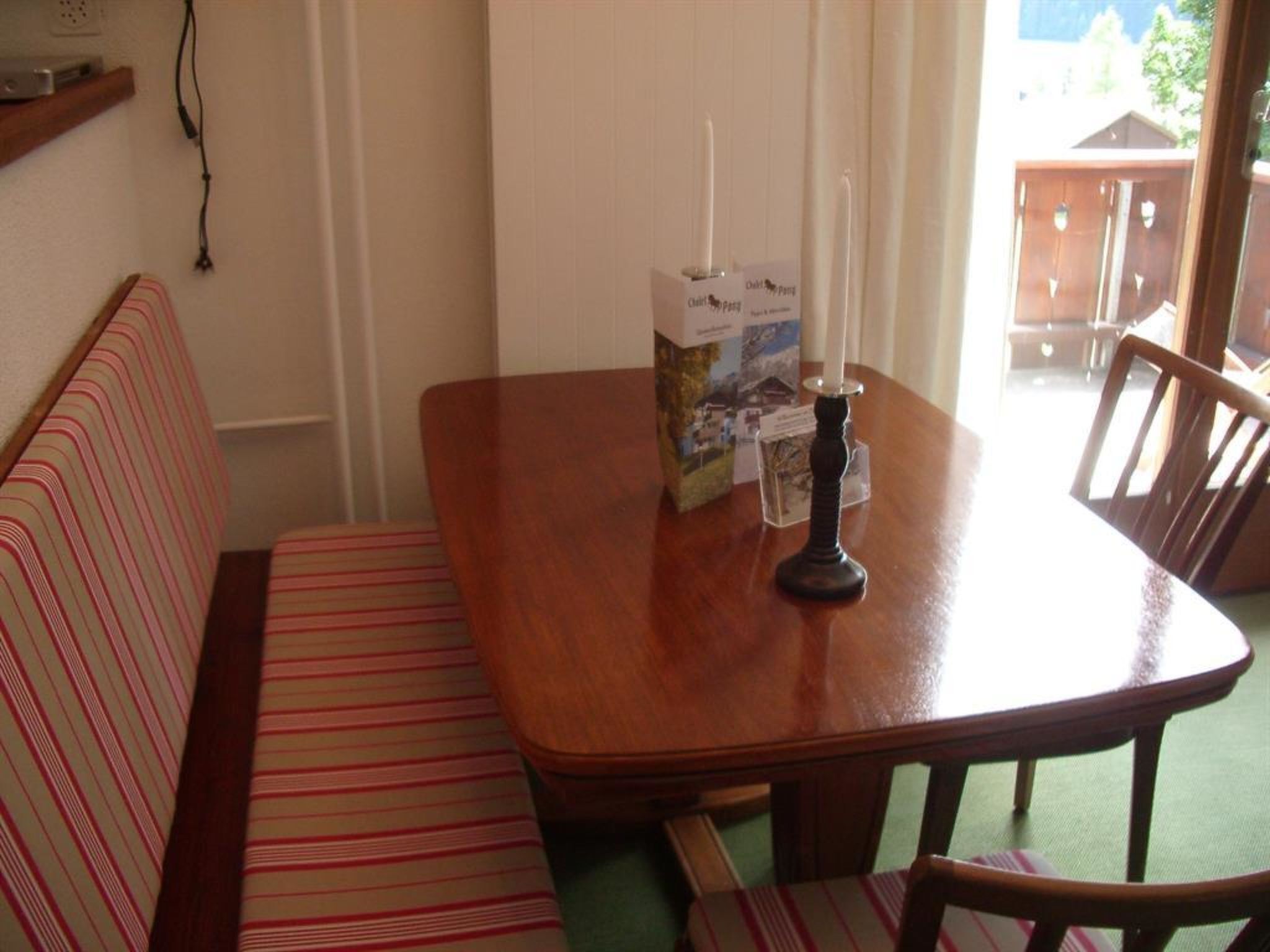 A dining area with a wooden table, a bench, and a candle.