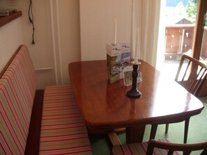 Ein Essbereich mit Holztisch, einer Bank und einer Kerze.