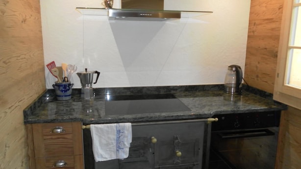 A kitchen with a stainless steel range hood, a coffee maker, and a kettle on the countertop. - Gwunderstübli Appartement/Fewo, Dusche oder Bad, WC, Wohn-/Schlafraum by Interhome (Lenk)