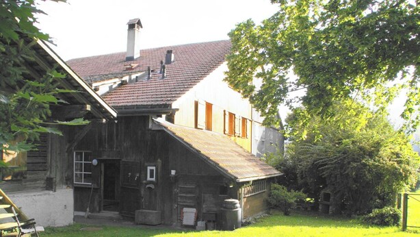 A rustic wooden building with a sloped roof, a chimney, and a small porch area. - Adlemsried Appartement/Fewo, Dusche oder Bad, WC, 4 oder mehr Schlafräume by Interhome (Boltigen)