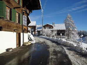 A snow-covered street with wooden buildings, a clear sky, and a snow-covered tree. - Adlemsried Appartement/Fewo, Dusche oder Bad, WC, 4 oder mehr Schlafräume by Interhome (Boltigen)