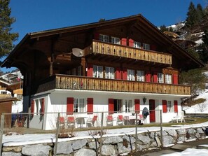 A multi-story chalet with balconies, a stone facade, and outdoor seating. - Bärnermutz # 2 Appartement/Fewo, Dusche oder Bad, WC, 2 Schlafräume by Interhome (Lenk)