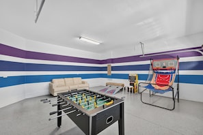 A room with a foosball table, a sofa, and a basketball hoop. - 6BR Encore w/ Under-the-Sea Kids' Room & Pool (Kissimmee)