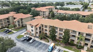 A multi-story residential building with a parking lot in front. - Bella Piazza Serenade | 3BR/3BA Davenport, Balcony (Davenport)