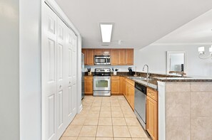 A kitchen with white cabinets, stainless steel appliances, and a granite countertop. - Windy Hill Getaway | 3BR at Ocean Marsh (North Myrtle Beach)