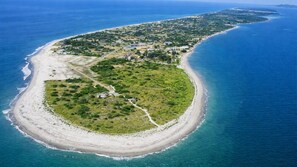 An aerial view of a coastal property with a beachfront, a road leading to the beach, and a cluster of buildings. - Cozy 2-Bedroom Home · Pool Access · Near Punta Chame Beach (Punta Chame)