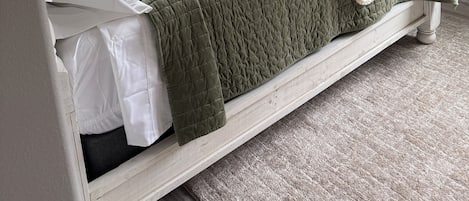 Une chambre à coucher avec un lit, une fenêtre et un luminaire au plafond.