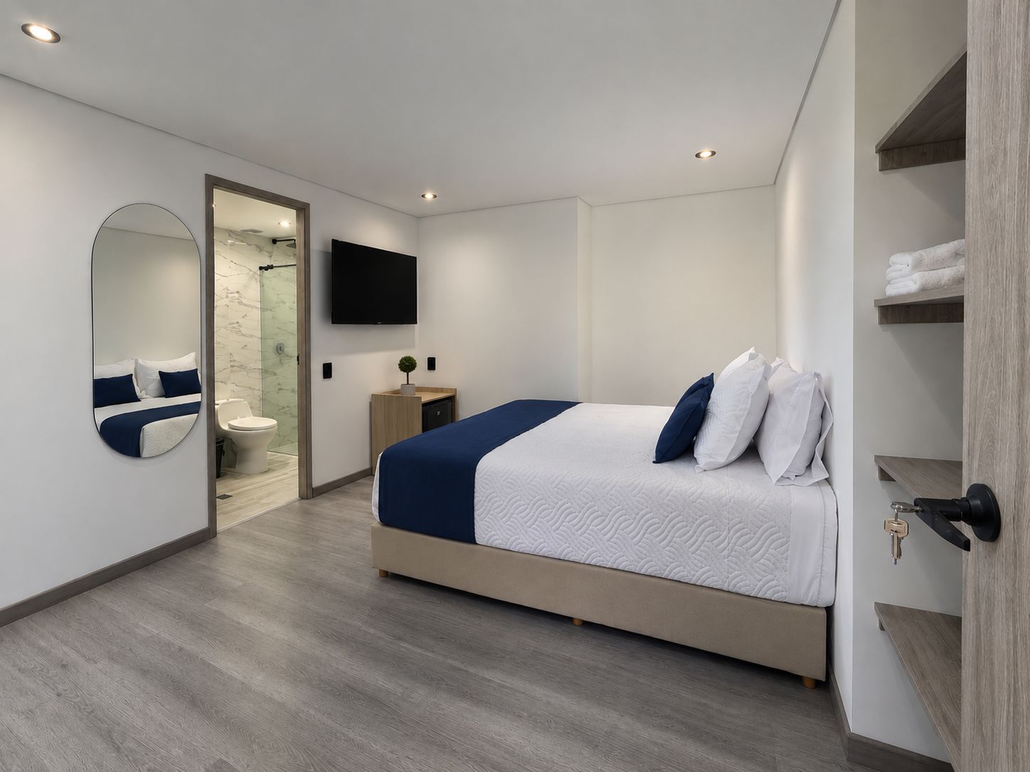 Ein modernes Hotelzimmer mit einem großen Bett, einem Badezimmer mit Dusche, einem Flachbildfernseher und einem Holzschrank.