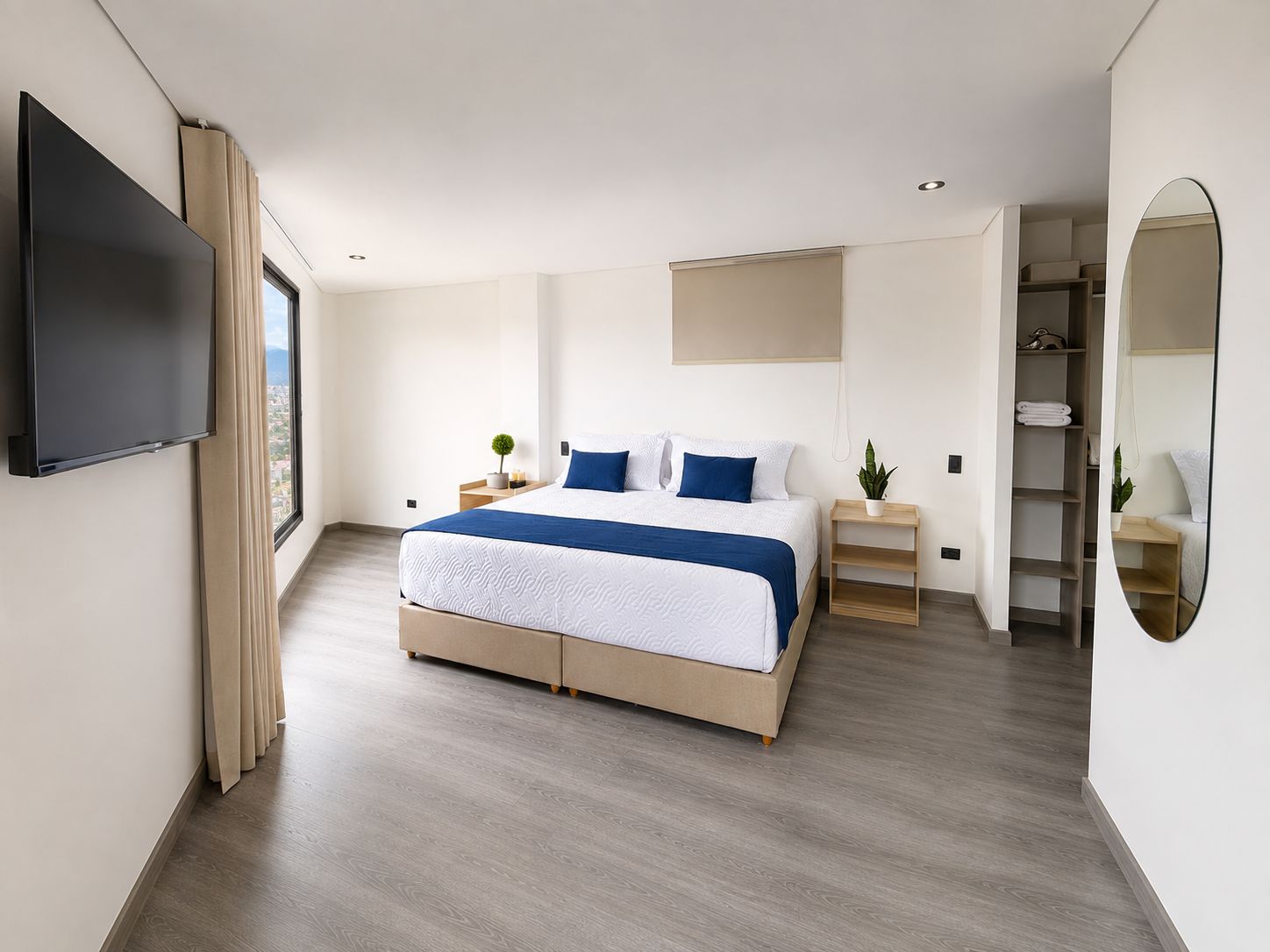 A modern bedroom with a large bed, bedside tables, a TV, and a wardrobe.