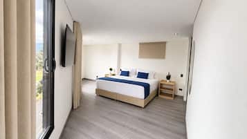 Camera da letto moderna con un grande letto, una televisione a muro e una finestra con tende.