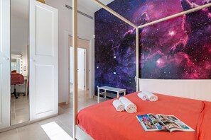 A bedroom with a starry nebula wallpaper, a bed with a red cover, and a magazine on the bed. - Villa Fedalì With Pool, Francavilla Fontana, Italy (Francavilla Fontana)
