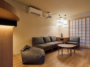 A modern living room with a sofa, a small table, and a bean bag. - Entire Building Rental in the Tsutenkaku/Shinsekai Area | "Recharge" in a Private Sauna & Cold Plunge Pool | Accommodates up to 12 People (大阪市)