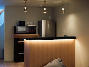 A modern kitchen with a wooden countertop, stainless steel appliances, and pendant lighting. - Entire Building Rental in the Tsutenkaku/Shinsekai Area | "Recharge" in a Private Sauna & Cold Plunge Pool | Accommodates up to 12 People (大阪市)