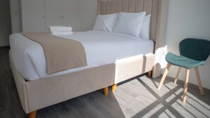 Ein Bett mit Kopfteil, ein Sessel und ein Kleiderschrank in einem Zimmer.