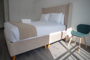 Ein Bett mit Kopfteil, ein Sessel und ein Kleiderschrank in einem Zimmer.